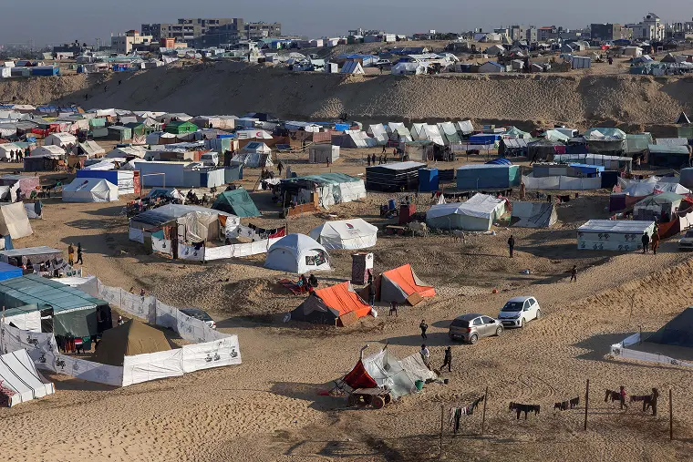Displaced people camping on a beach near the Egyptian border in Rafah
